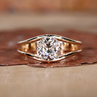 A stunning split shank diamond ring with a sparkling center stone.