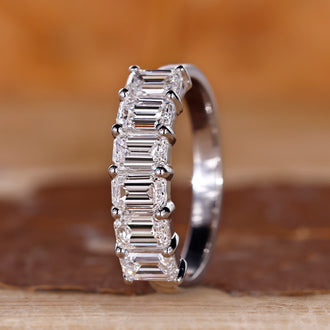 Emerald cut wedding band in shared prong setting.