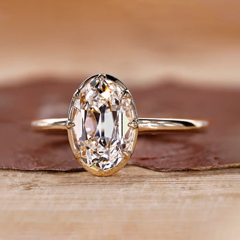 Oval old European cut diamond ring with claw prong setting in yellow gold.