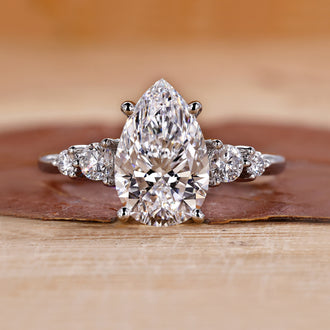 5 stone diamond ring with pear-cut center stone.
