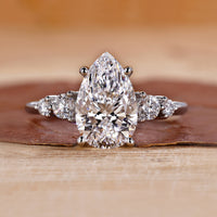 5 stone diamond ring with pear-cut center stone.