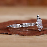 White gold engagement ring with a delicate pear halo design.