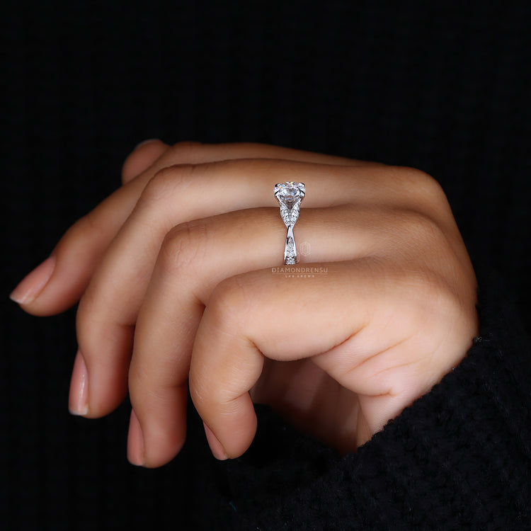 Round diamond engagement ring with claw prongs and split shank, embodying a nature-inspired theme.
