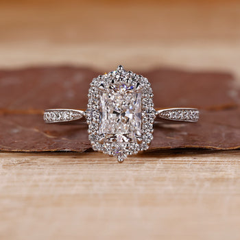 Radiant halo engagement ring with round cut diamond center stone.