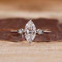 Marquise and round diamond ring in white gold with compass prong setting.