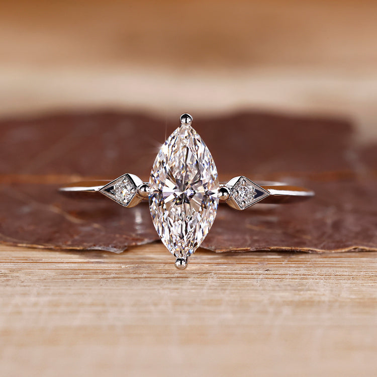Marquise and round diamond ring in white gold with compass prong setting.