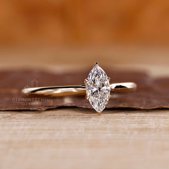 Yellow gold ring with cathedral setting and marquise diamond center.