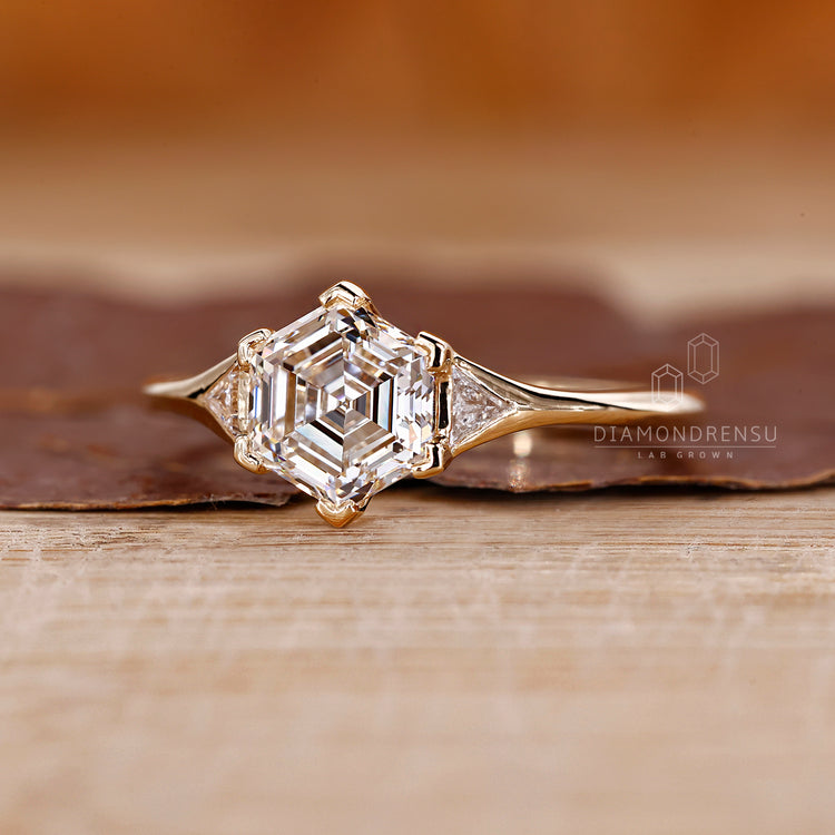 Triangle side diamond yellow gold engagement ring.