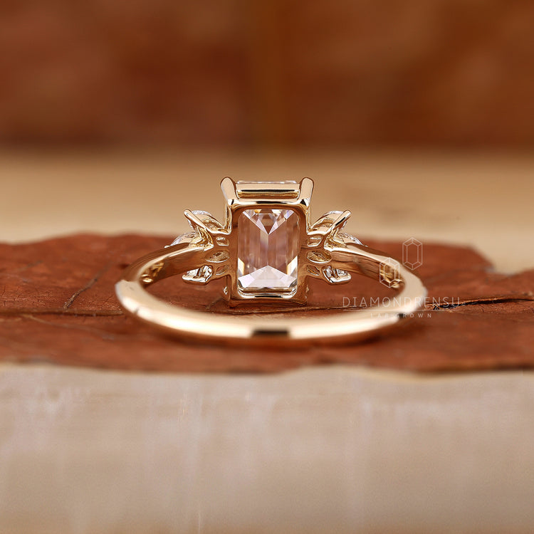 Handmade ring featuring a stunning emerald cut emerald and marquise Diamonds.