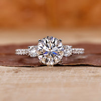 Elegant 3 stone diamond engagement ring with a milgrain band.