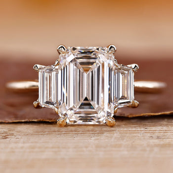 Three stone emerald cut ring with stunning diamond accents for an elegant look.