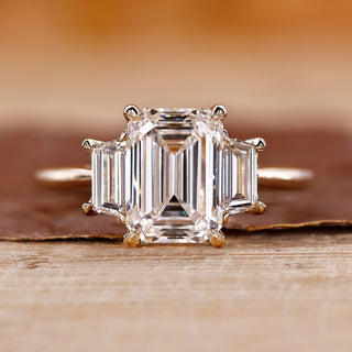 Three stone emerald cut ring with stunning diamond accents for an elegant look.
