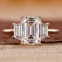 Three stone emerald cut ring with stunning diamond accents for an elegant look.