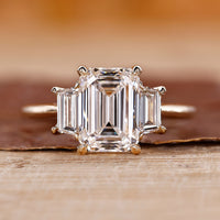 Three stone emerald cut ring with stunning diamond accents for an elegant look.