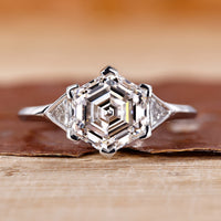 Hexagon diamond engagement ring with bezel setting in white gold.