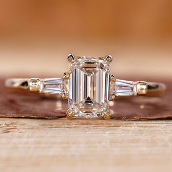3 Stone Emerald Cut Diamond Ring with tapered baguette accents.
