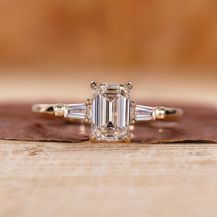 3 Stone Emerald Cut Diamond Ring with tapered baguette accents.