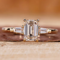 3 Stone Emerald Cut Diamond Ring with tapered baguette accents.