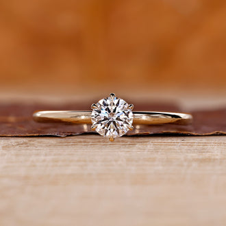 Diamondrensu engagement ring crafted with round diamond solitaire and gold prongs.