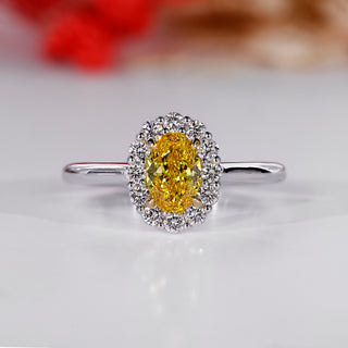 Oval cluster halo ring with canary yellow oval diamond center.