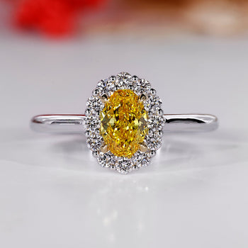 Oval cluster halo ring with canary yellow oval diamond center.