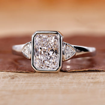 Three Stone Bezel Ring featuring radiant cut diamonds.