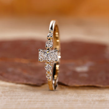 Radiant Cut Engagement Ring with round cut side stones in yellow gold.