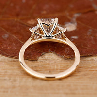 Elegant cathedral engagement ring with a three stone emerald cut design.