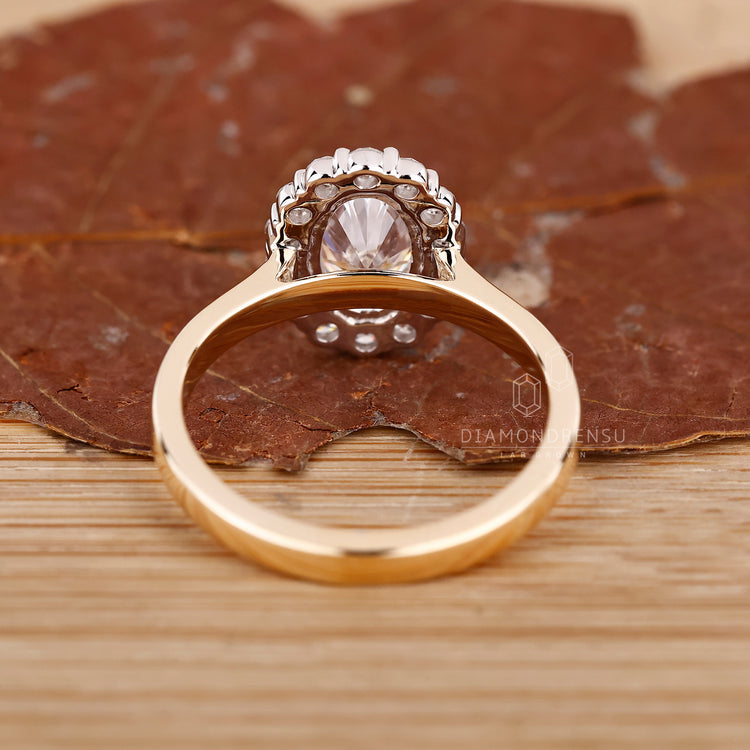 Custom engagement ring featuring halo diamond style in two tone metal