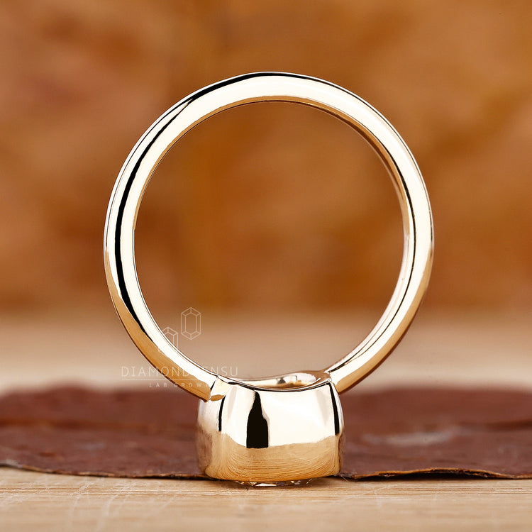 Yellow gold ring engagement with a bezel set cushion diamond for a modern touch.