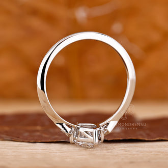 Handmade ring with marquise and round side stones in compass prong setting.