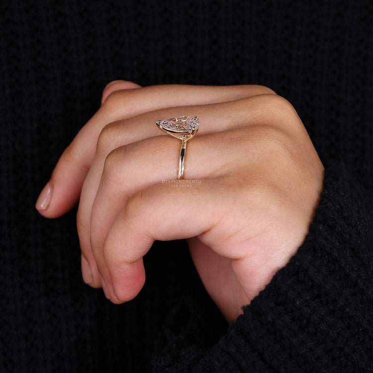 Yellow gold engagement ring with a pear-shaped diamond for a traditional look.