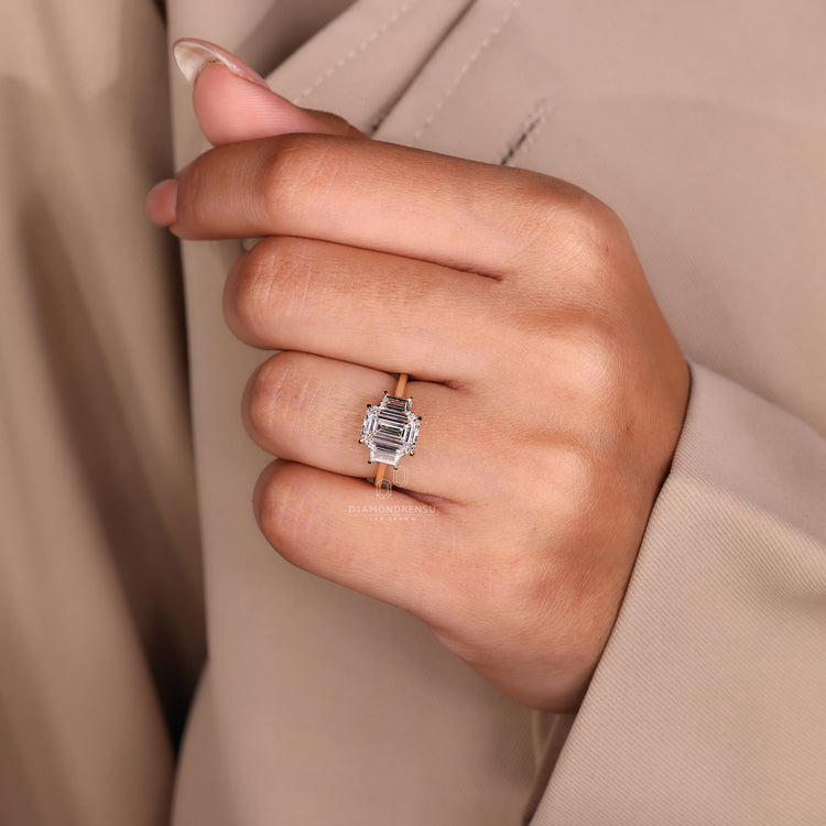 Cathedral ring setting featuring a sparkling three stone emerald cut diamond.