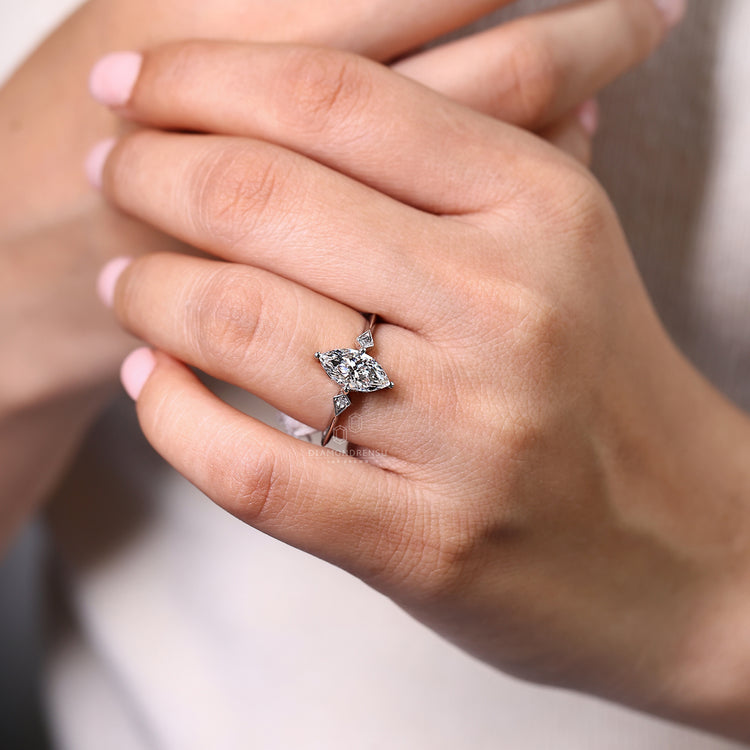 Knife edge shank ring with marquise centre and round side diamond.