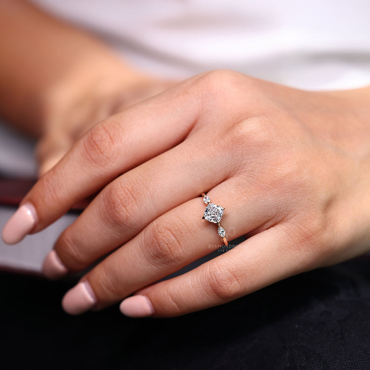 Marquise side stone complements cushion center diamond.