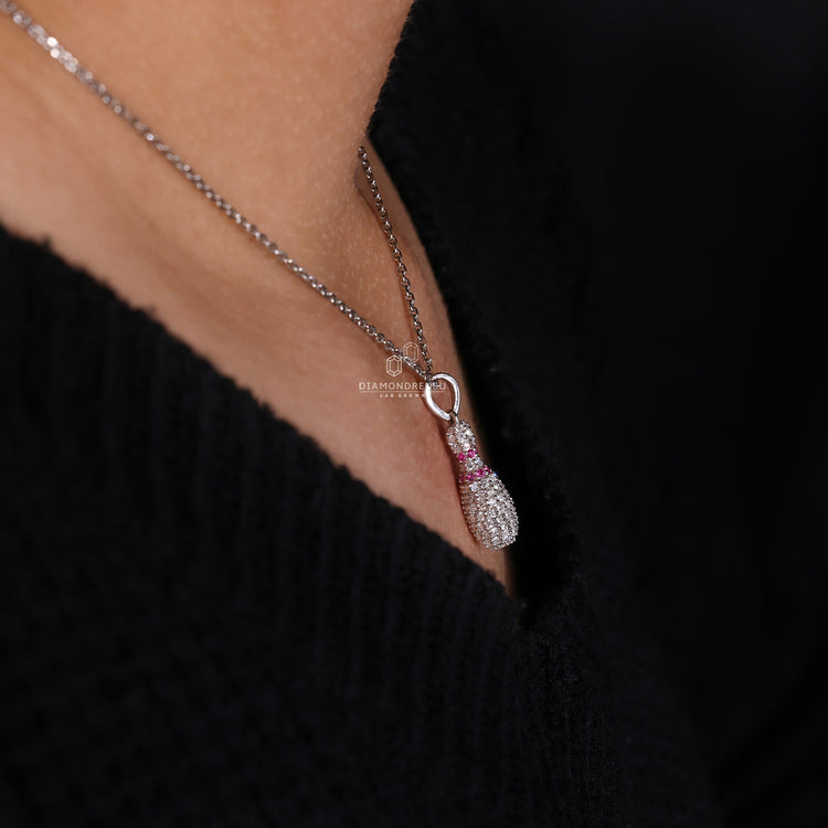 Gold Bowling Pin charm pendant with prong set round diamonds.