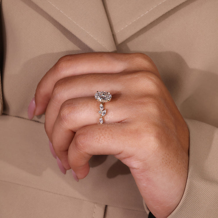 Sidestone engagement ring with round and marquise diamond details.