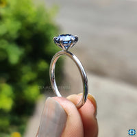 Six-prong round setting holding a moissanite stone.
