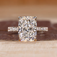 Elongated cushion ring with pave setting in round cut pave band.