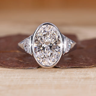 3 stone diamond ring with oval cut center diamond and half moon cut side stones.