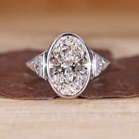 3 stone diamond ring with oval cut center diamond and half moon cut side stones.
