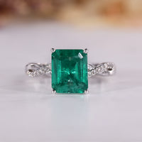 Emerald birthstone ring with green emerald and twisted shank design.
