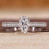 Coffin cut diamond ring with pave style band and round diamond accents.