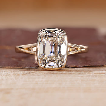 Bezel set diamond ring with cushion old mine cut diamond in solitaire setting.