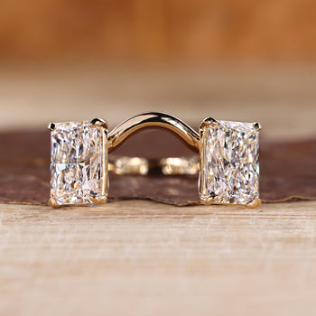 Radiant cut gold engagement ring featuring two stone design in yellow gold.