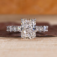 Radiant diamond ring with pave setting in white gold.