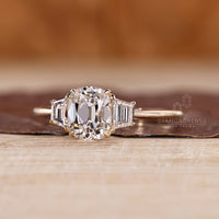 Cushion old mine diamond ring with trapezoid accents and prong setting.