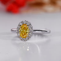 Halo engagement ring with center oval diamond and white gold band.