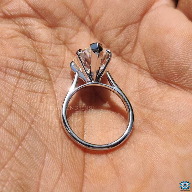 Solitaire moissanite ring with a handmade white gold cathedral design.