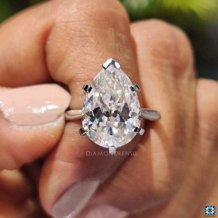 Pear cut moissanite ring with v prong support in a white gold band.